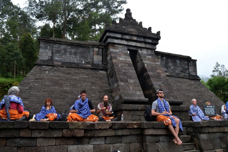 Foreign visitors studying Javanese spiritualism meditate at Cetho Temple in Central Java. 