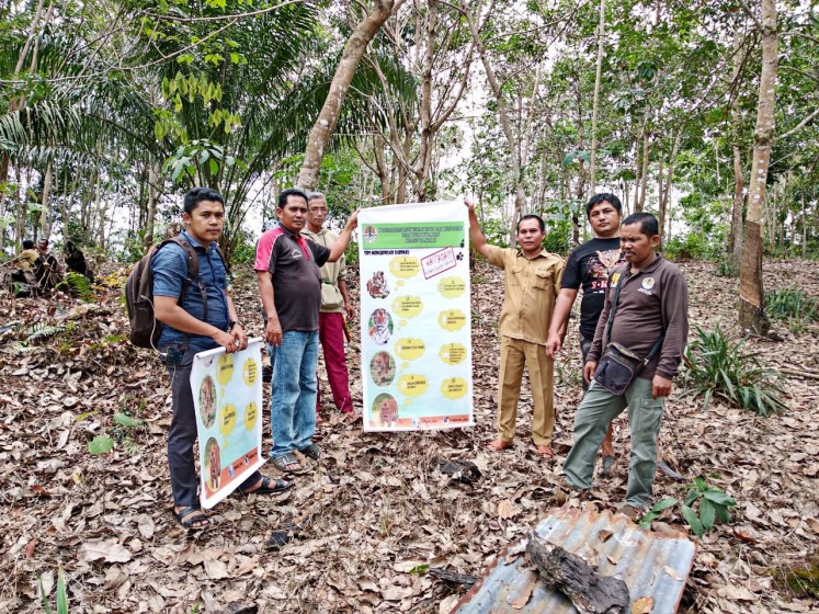 Members of a Quick Response team dispatched by the Riau Natural Resources Conservation Agency examine the suspected Sumatran tiger prints on Tuesday. 