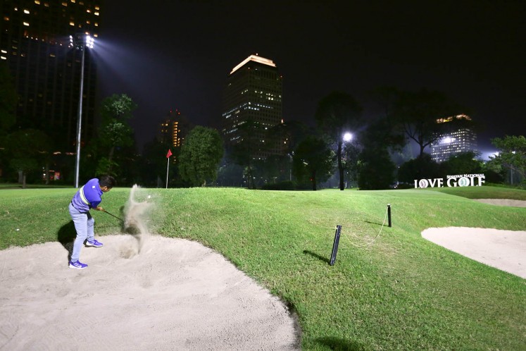 A golfer chips off from a bunker at the Senayan National Golf Club.