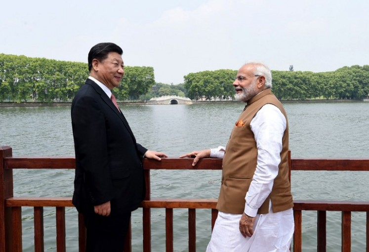 This handout photograph released by India's Press Information Bureau (PIB) on April 28, 2018 shows India's Prime Minister Narendra Modi (right) and Chinese President Xi Jinping looking on along the East Lake, in Wuhan. Chinese President Xi Jinping and Prime Minister Narendra Modi ended informal meetings in China on April 28 with a promise to reduce border tensions after a high-altitude standoff in the Himalayas last year.