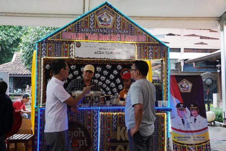 Central Aceh Regent Shabela Abubakar (second left) engages with visitors at the festival's Central Aceh booth.