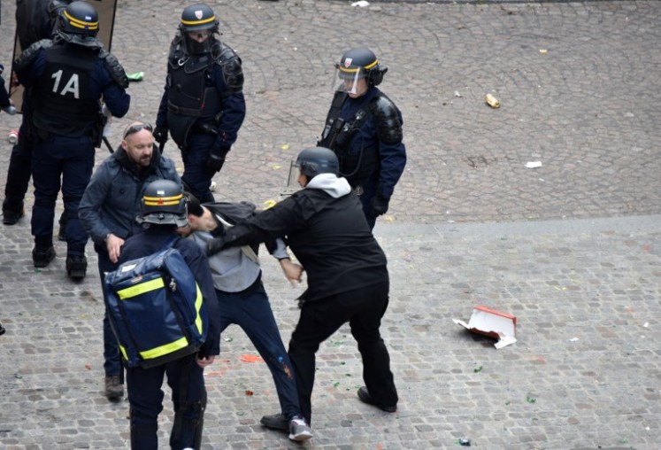 Elysee Chief Security Officer Alexandre Benalla (center) wearing a police visor, next to Vincent Crase (center, left), a security aide for Macron's Republic on the Move party, as they drag away a demonstrator during May 1 protests in Paris. (Naguib-Michel Sidhom / AFP)