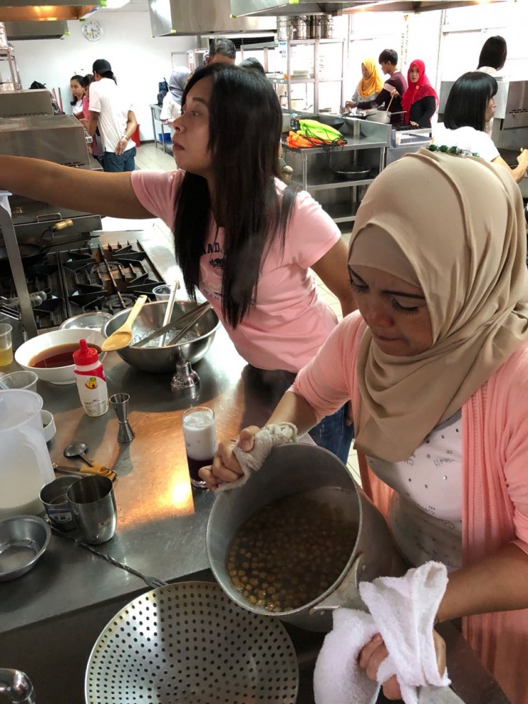 Indonesian migrant workers learn how to make bubble tea.