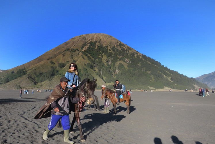 Tourists can ride a horse to go to the crater or return to the jeep parking area. The horse is provided by Tengger tribe members. 