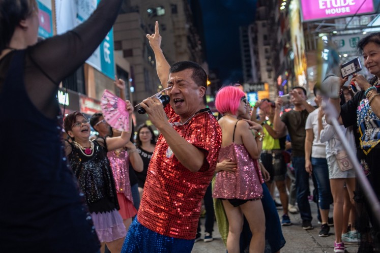 People sing and dance at the pedestrian zone of Sai Yeung Choi Street South in Mong Kok, Hong Kong