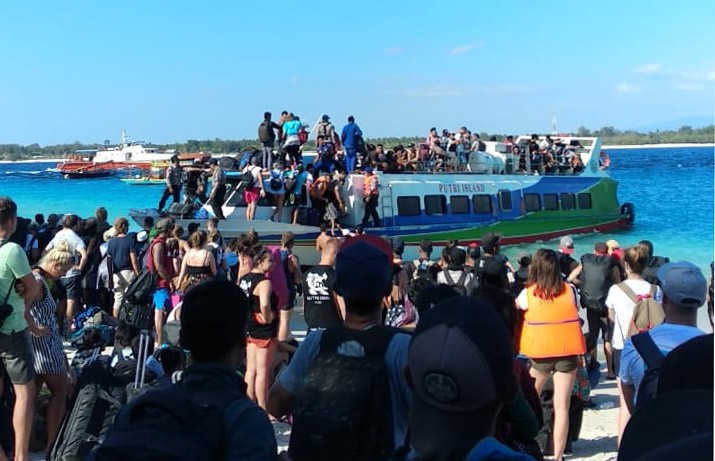 People crowd the shore as they attempt to leave Gili Trawangan Island in West Nusa Tenggara on Aug. 6. 