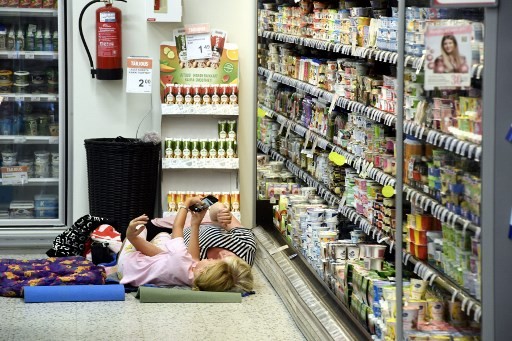 Women take a selfie next to cooling shelves in a local grocery store that invites customers for a sleepover to cool off as the heatwave in Europe continues, in Helsinki, on August 4, 2018. 
 