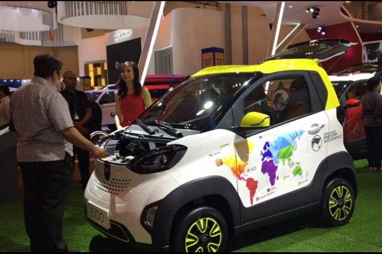 A visitor talks to a sales representative about small electric car E100 by Wuling at GIIAS 2018 in Tangerang, Banten, from Aug. 2 to 12.