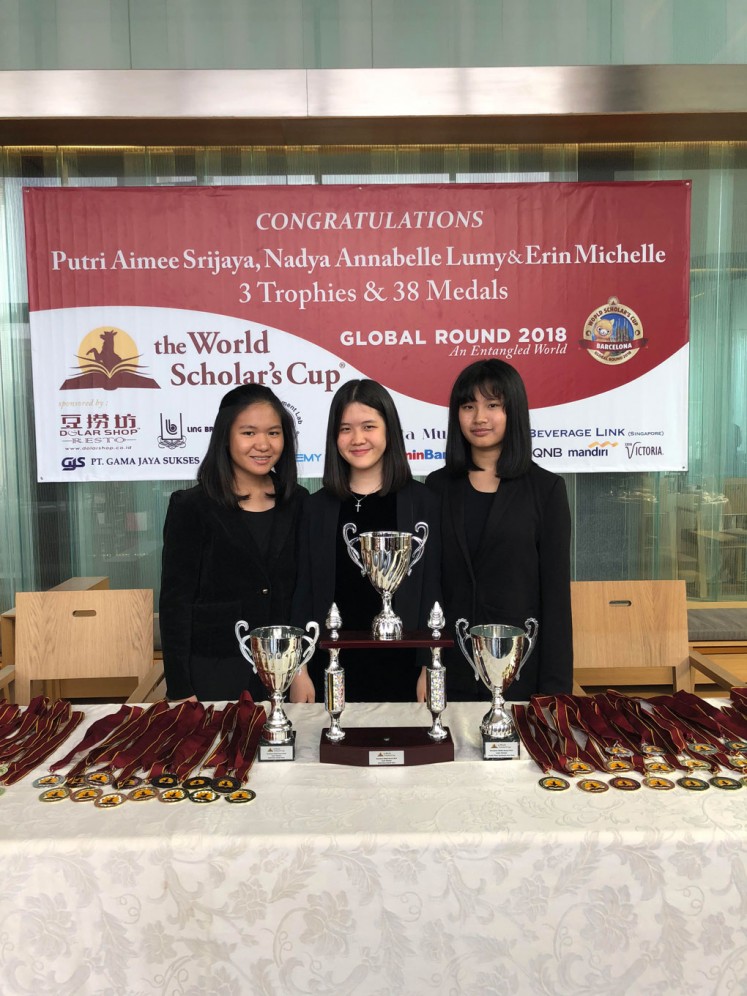 Nadya Annabelle Lumy (left), Putri Aimee Srijaya (center) and Erin Michelle pose for a photo with the three trophies and 38 medals they won at the World Scholar's Cup in Barcelona.