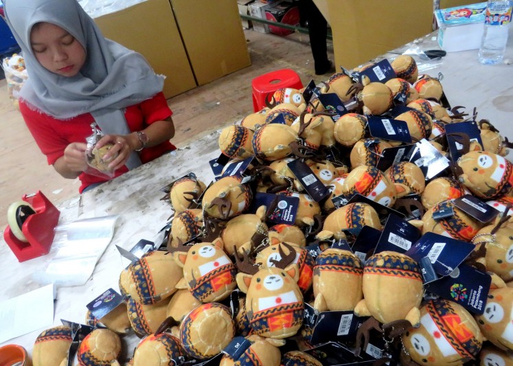 An employee of Istana Boneka packs dolls of Atung the Bawean deer at the company's factory in Malang, East Java, on Friday, Aug. 10, 2018.