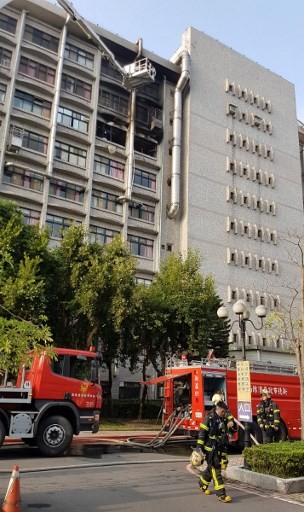 This photograph by Taiwan agency CNA Photo taken on August 13, 2018 shows firetrucks outside a nine-storey hospital in New Taipei City after battling a fire at a hospice that broke out on the seventh floor (top C). Nine people were killed and 15 injured in a blaze that broke out early on August 13 at the hospice for the terminally ill, near Taiwan's capital Taipei, fire officials said.
