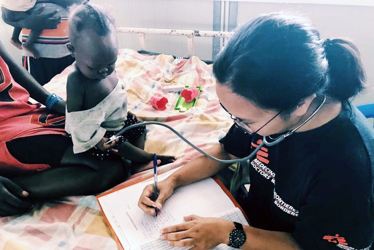At work: Rangi Wirantika writes information about a patient in South Sudan.