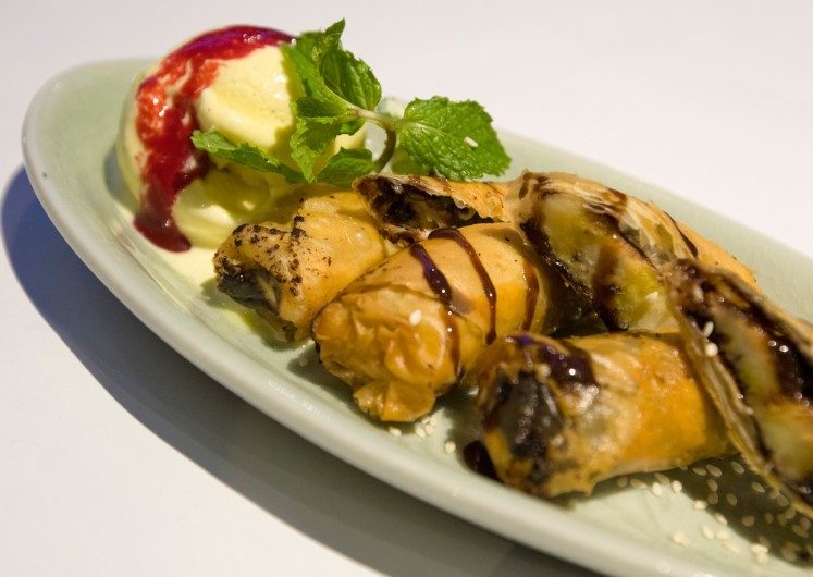 'Piscok goreng' is deep-fried banana wrapped in filo pastry with chocolate sauce and a scoop of vanilla ice cream.