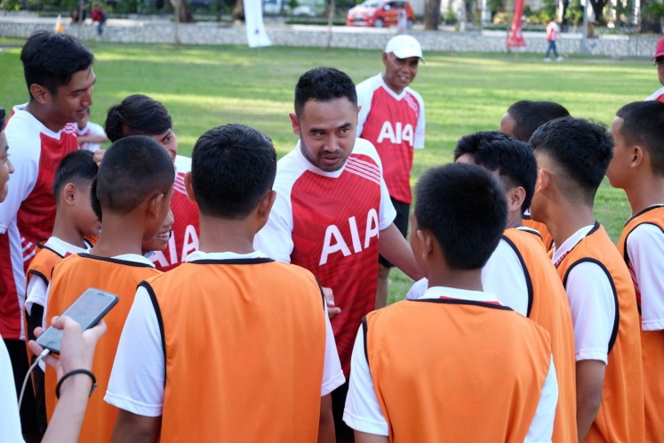 Veteran advice: National soccer player Ponaryo Astaman (center) talks with young soccer players in Makassar during a PT AIA Financial coaching clinic on Aug. 6 designed to help raise awareness among youths on the importance of healthy living.