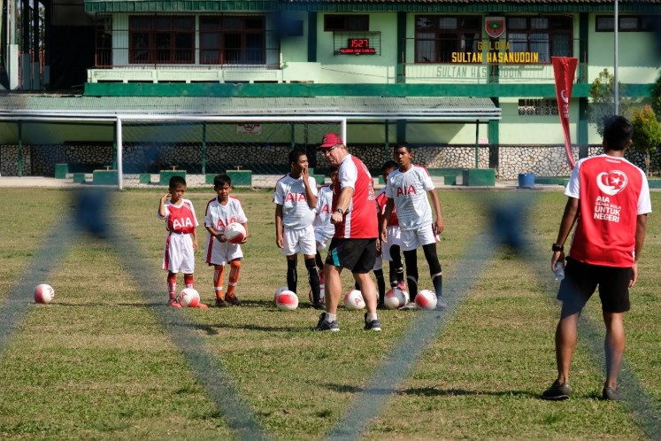 Coaching from the pros: PSM Makassar soccer club head coach Robert Rene Albert (center) gives young soccer players in Makassar, South Sulawesi, tips on how to improve their games on Aug. 6, as part of a PT AIA Financial coaching clinic to support healthy youths.