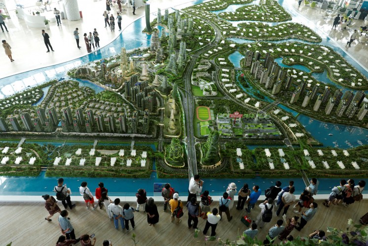 Prospective buyers look at a model of the development at the Country Gardens' Forest City showroom in Johor Bahru, Malaysia February 21, 2017. REUTERS/Edgar Su/File Photo