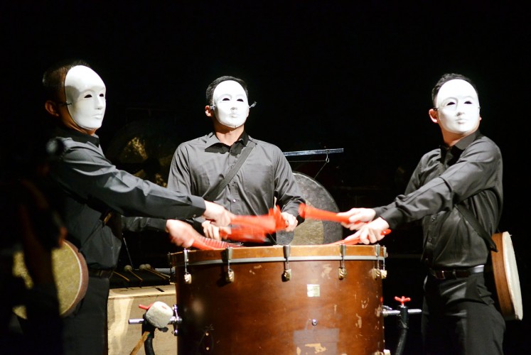 Masks on: Three Ju Percussion Group musicians in white masks beat the Chinese bass drum with red folding fans in order to perform Chang Chiung-Ying’s “Solar Myth” piece.