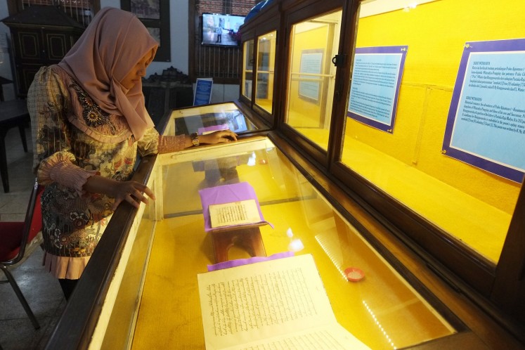 A visitor looks at an ancient manuscript in the exhibition.
