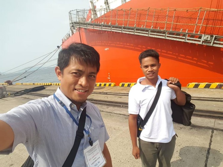 Aldi Novel Adilang (right), 19, poses with an Indonesian consular official upon landing in Japan after being stranded for 49 days in Guam waters.