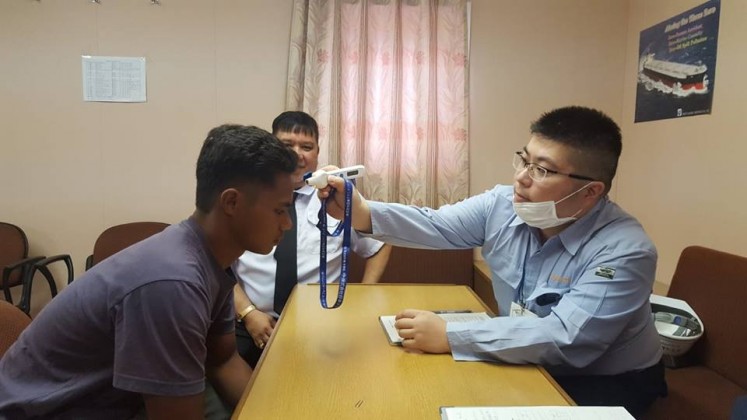 Aldi Novel Aldilang, 19, has his temperature taken by Japanese port authorities earlier this month. He was rescued after 49 days adrift in Guam waters.