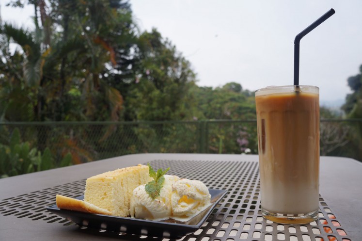 Visitors can enjoy lemon cake and iced latte with a mountainous view at Kiputih Satu cafe in Ciumbuleuit.