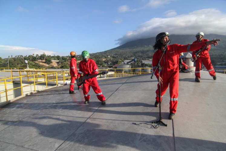 Indonesian rock band Boomerang performs on top of a silo at the Wilmar International refinery in Bitung, North Sulawesi.