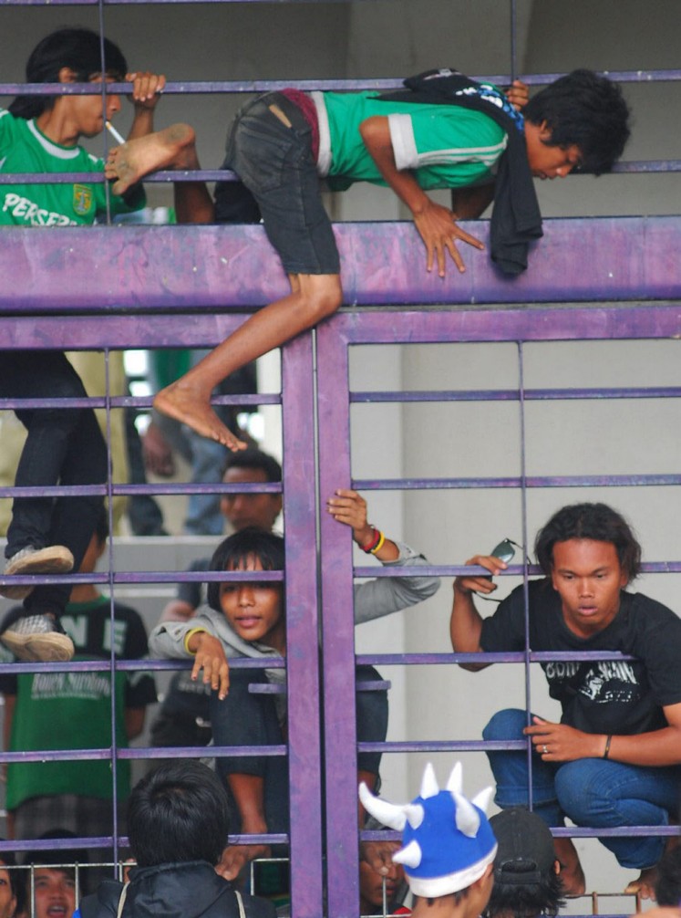 Supporters of Persebaya Surabaya, known as Bondo Nekat (Bonek), attempt to enter Jalak Harupat Stadium in Bandung, West Java, by climbing over the gate.