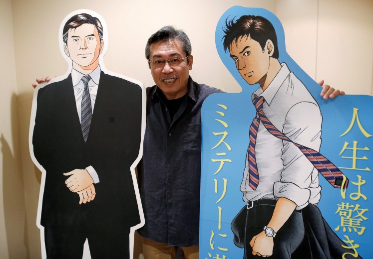 Kenshi Hirokane, the comic book author of the 'Kosaku Shima' and 'Like Shooting Stars in the Twilight' series, poses with cutouts of Kosaku Shima characters during an interview with Reuters at his studio in Tokyo, Japan September 10, 2018. 