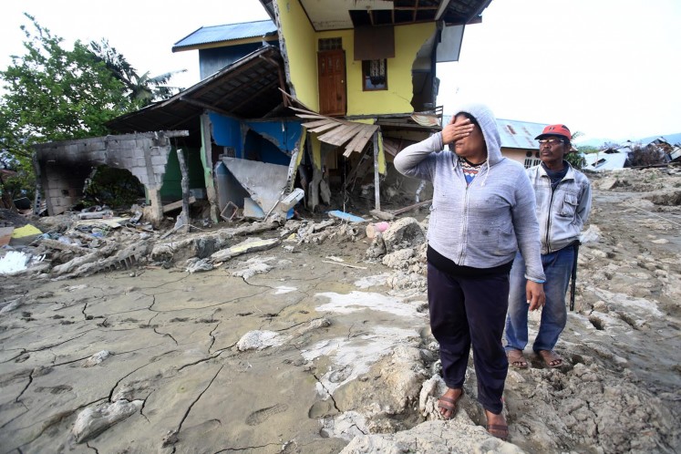 Survivors search for the exact location of their houses, which shifted as a result of soil liquefaction, in Petobo district, Palu, Central Sulawesi, on Oct. 3. Search and rescue teams are having difficulties in retrieving bodies buried in the mud.