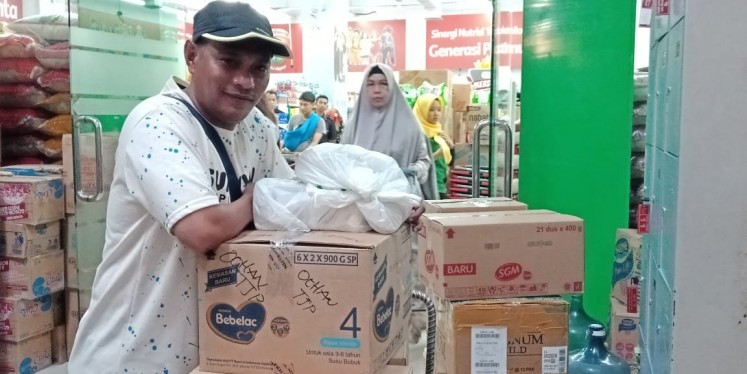 Ruslan Sangadji poses with aid supplies he bought in Makassar, South Sulawesi, on Friday (Oct. 5, 2018)