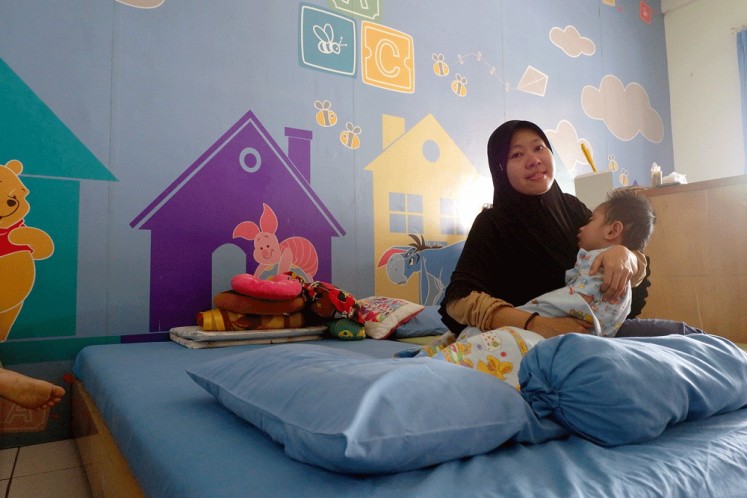 Holding on: Hendri Handayani holds her baby, Arsyil Fadillah, who has been diagnosed with Anaplastic Ependymoma brain tumor.