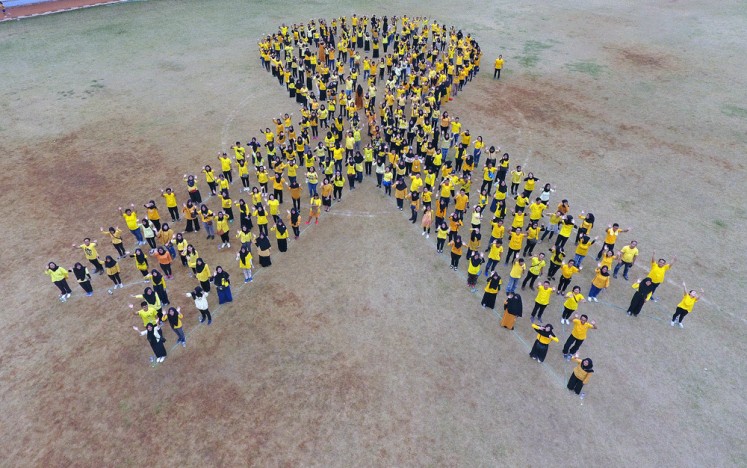 Cancer awareness: Participants of the 2018 Anyo Gold Ribbon Configuration form a huge yellow ribbon in Jakarta as part of a campaign for International Childhood Cancer Awareness Month in September.
