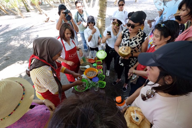 Tour participants enjoy a hands-on cooking demo at Lako Akelamo village, a coastal area in Jailolo, West Halmahera, North Maluku.