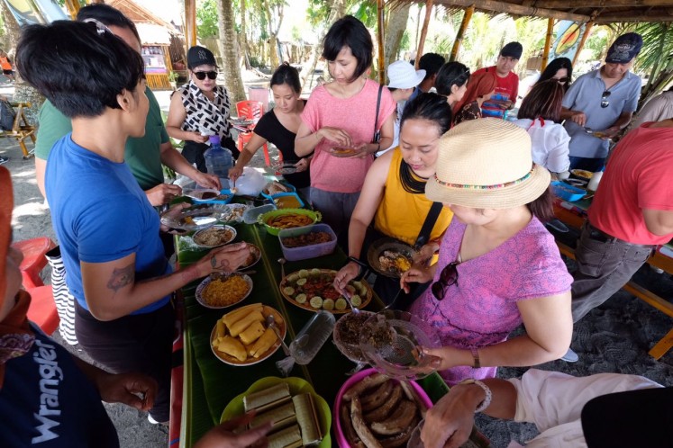 Tour participants sample traditional food at Lako Akelamo village, a coastal area in Jailolo, West Halmahera, North Maluku.