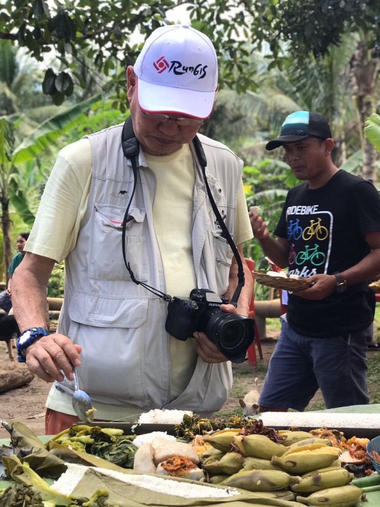 Culinary expert William Wongso samples food at Ngaon village, a farmland area in Jailolo, West Halmahera, North Maluku.