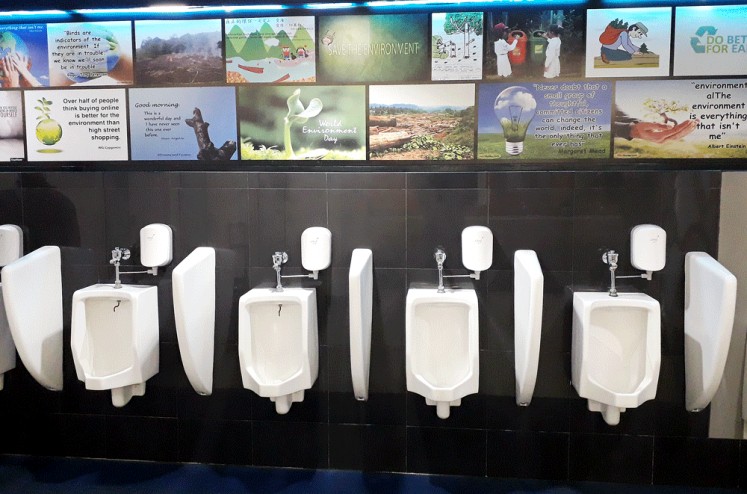 Save the forest: Posters and photos about saving the environment grace the walls of the public toilets at Sultan Syarif Kasim Airport in Pekanbaru, Riau. 