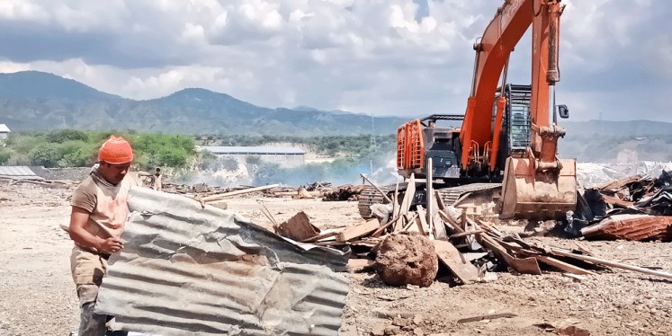 Workers use a backhoe to clear away debris on Wednesday at a destroyed warehouse complex in Mamboro, Palu city, Central Sulawesi, that was hit by last month’s tsunami.