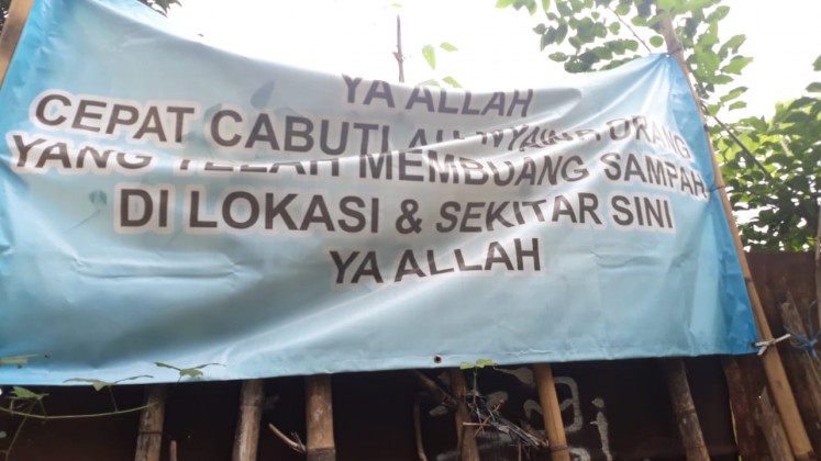 A banner, found on the side of Jl. Aria Putra in Jombang, Ciputat, in South Tangerang, says, “God, please take the lives of anyone who litters here!”