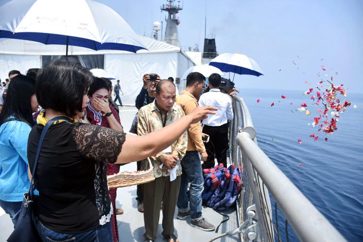 Family members of the Lion Air flight JT610 crash victims scatter flowers from the deck of KRI Banjar Masin into the sea near Karawang, West Java, in a ceremony held on Tuesday to pray for their loved ones. 