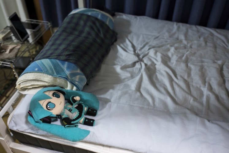 A doll of Japanese virtual reality singer Hatsune Miku, wearing a wedding ring, lies on the bed of Japanese Akihiko Kondo, at his apartment in Tokyo, a week after their marriage.