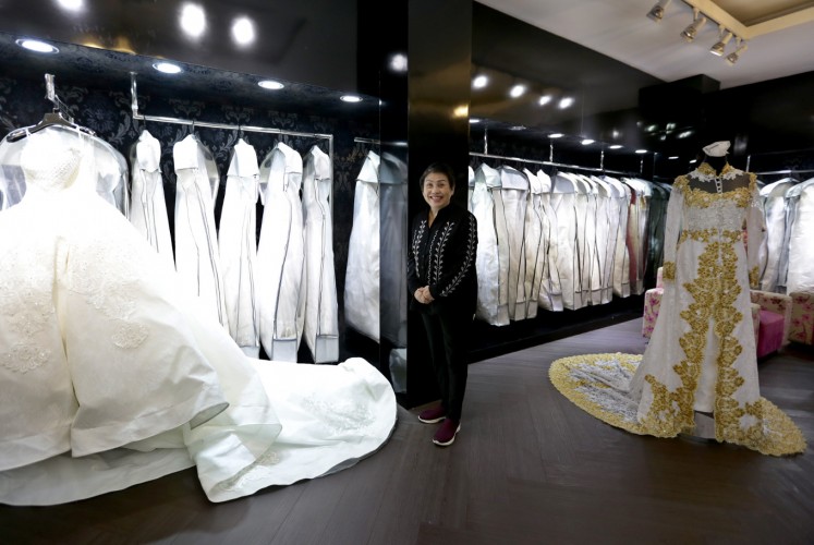 Eva, the owner of Eva Bun, stands amid her dresses at the Eva Bun Wedding Gallery in Central Jakarta on Friday.