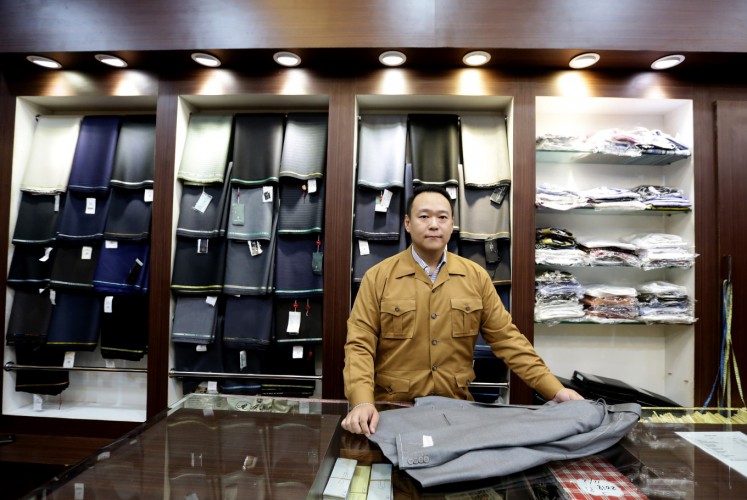 The director of Atham Tailor, Don Tjong, poses before fabrics for their bespoke suits at the Plaza Indonesia mall in Central Jakarta on Wednesday.
