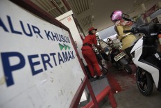 A gas station employee serves motorists with Pertamax non-subsidized fuel at a Cikini gas station in Central Jakarta.