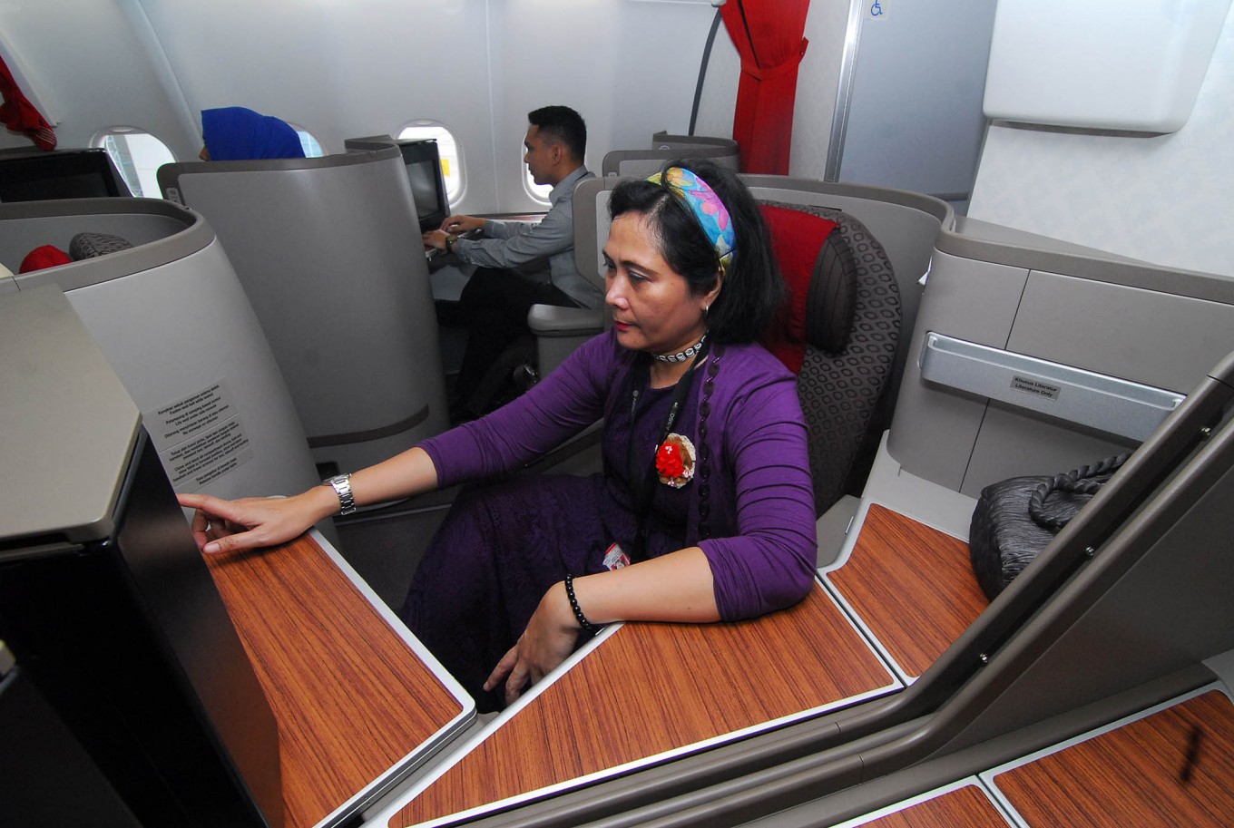 A Garuda Indonesia stewardess checks a seat in Garuda's latest airplane, the Airbus 330-300, at Tangerang, Banten, on Feb. 1. 