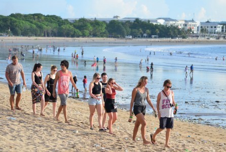 Foreign tourists are pictured walking on February 2016 on Bali's famous Kuta Beach.