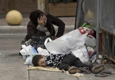 A boy of a migrant family sleeps on the pavement, in Athens, Monday, Feb. 29, 2016, at the Victoria Square, where most newly-landed migrants head after reaching the Greek capital from the Aegean Sea islands. Border restrictions further north in the Balkans have left thousands of refugees and other migrants stranded in a country that is still wracked by its own financial crisis and unable to seal its lengthy sea border with Turkey.