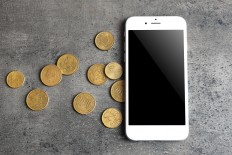 Mobile phone and money on grey background. A prisoner in Kosovo had swallowed an entire mobile phone.