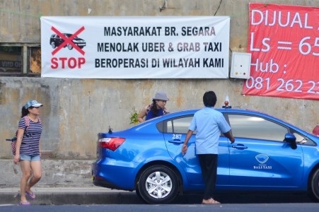 A poster protesting against application-based taxis is seen on Feb. 20 in Kuta, Bali. Similar posters have been put in several locations around the island in a protest against the operations of Gojek and Grab.
