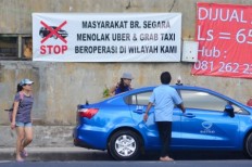 A poster protesting against application-based taxis is seen on Feb. 20 in Kuta, Bali. Similar posters have been put in several locations around the island in a protest against the operations of Gojek and Grab.