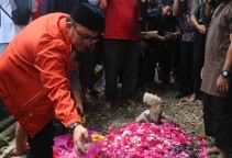 Former chairman of Muhammadiyah's youth wing Dahnil Anzar Simanjuntak (left) puts flowers on the grave of suspected terrorist Siyono, who died while in police custody. 